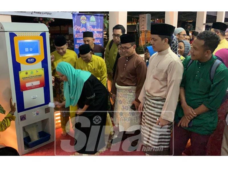 Penerima menyentuh kad pintar di mesin ATM beras.