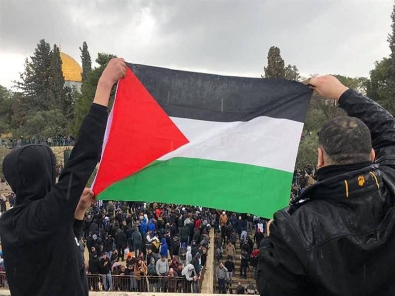 Penduduk Palestin mengibarkan bendera kebangsaan sebagai tanda gembira.
