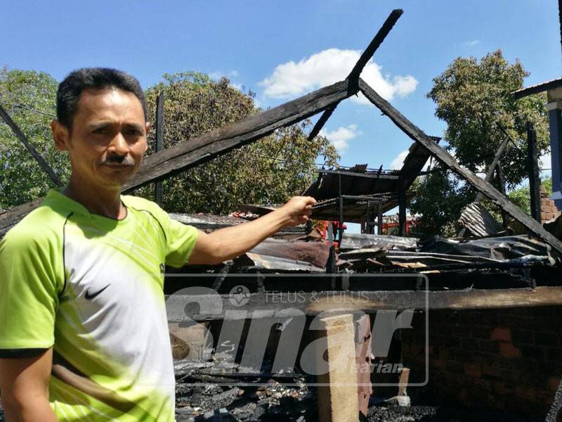 Wan Hassan menunjukkan rumah yang menjadi tempat mereka sekeluarga berteduh musnah dalam kebakaran di Kampung Bagus.