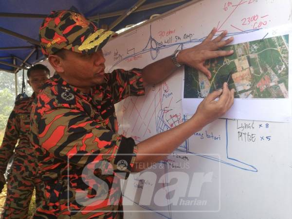 Nor Hisham menunjukkan perancangan pihak bomba kepada media dalam memadamkan kebakaran di kawasan tersebut.