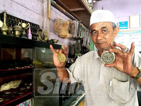Pak Mat menunjukkan koleksi duit syiling lama.
