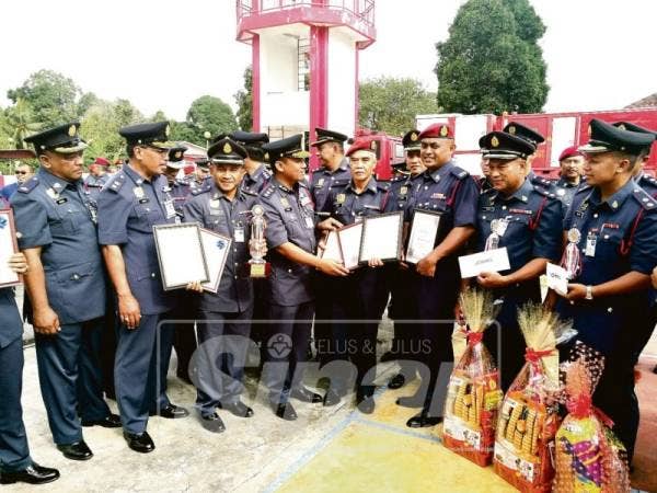 Nazili (empat, kiri) bersama anggota bomba yang menerima penghargaan selepas Majlis Perhimpunan Bulanan JBPM Kelantan di Balai Bomba dan Penyelamat Ketereh, semalam.