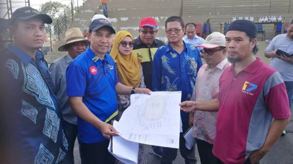 Abdul Yunus(tengah) tekun mendengar penerangan mengenai kerja membaik pulih dan menaik taraf Stadium Mini Bagan Serai daripada wakil kontraktor dilantik(kanan).