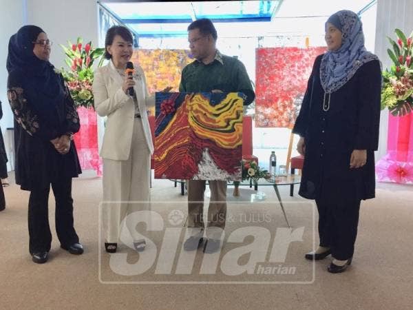 Saifuddin melelong hadian lukisannya kepada tetamu di Bard’s Art Exhibition, Petaling Jaya.
