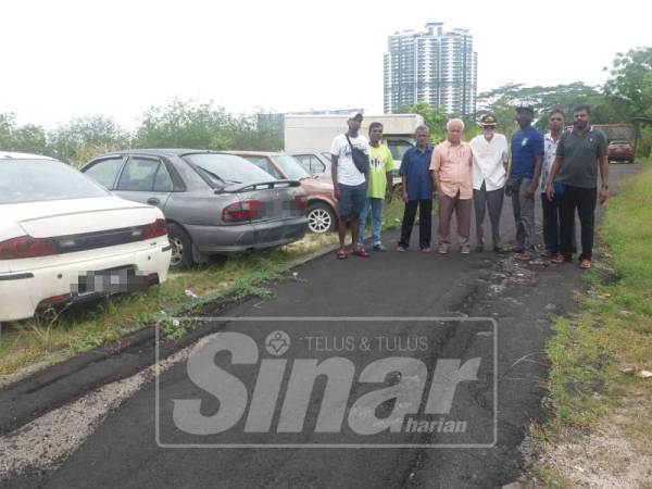 Hambali dan penduduk menunjukkan kenderaan lama yang dibiarkan tersadai.
