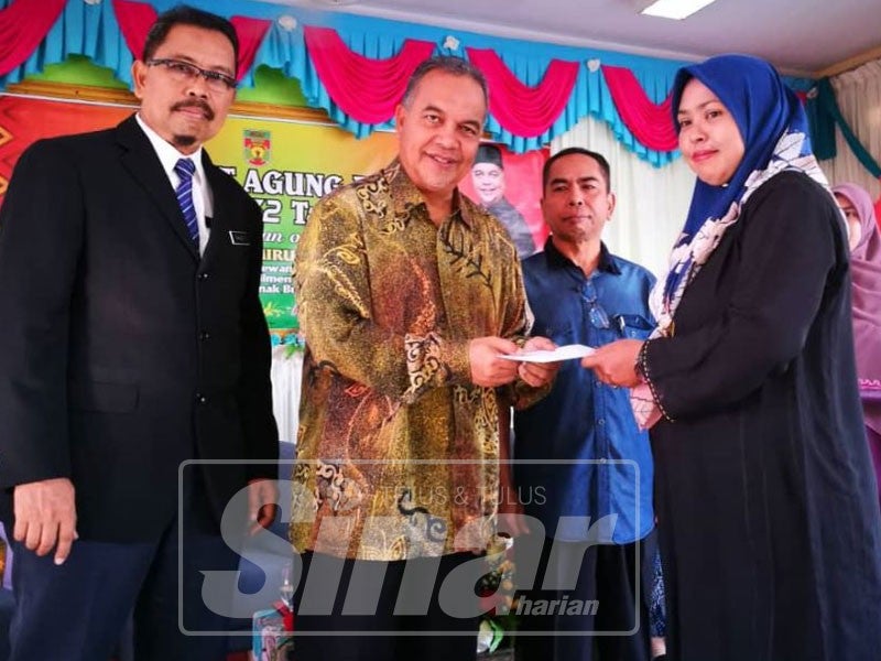 Amiruddin (dua, kiri) menyampaikan sumbangan zakat kepada waris pelajar.