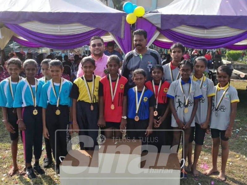  Mujahid (belakang, kanan) bergambar kenangan dengan atlet cilik SJKT St Mary, Parit Buntar pada hari sukan sekolah itu hari ini.