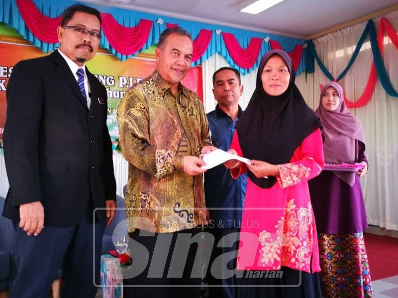 Amiruddin (dua, kiri) menyampaikan sumbangan zakat kepada waris pelajar.