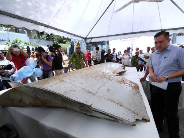 Anthony Loke melihat serpihan sayap bangkai pesawat MH370 yang dipamerkan sempena Majlis Memperingati Tragedi MH370 di ruang legar Publika hari ini. - Foto Bernama