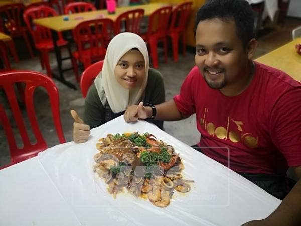 Zawani dan suami menunjukkan hidangan yang paling mendapat permintaan tinggi di kedai makan diusahakannya.