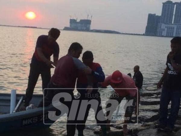 Mangsa dibawa naik ke darat oleh anggota bomba dengan bantuan nelayan tempatan.