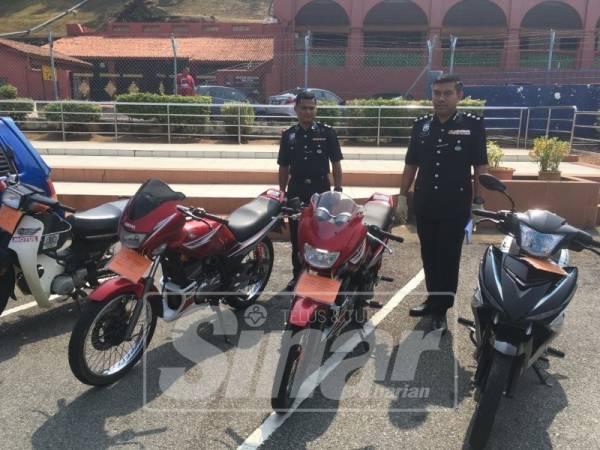 Afzanizar(kanan) menunjukkan sebahagian motosikal yang dirampas.