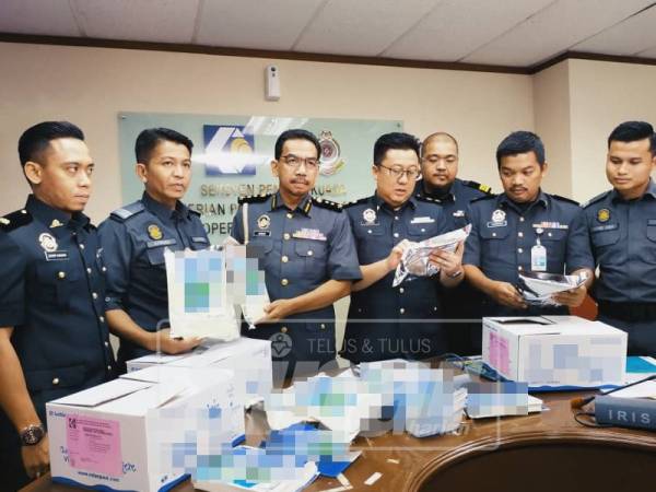 Azman (tiga dari kiri) menunjukkan susu dirampas oleh KPDNHEP.