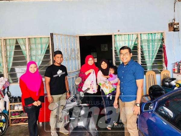 Nor Hasrul Akhmal (kanan) ketika menyampaikan bantuan keperluan harian kepada golongan memerlukan. 