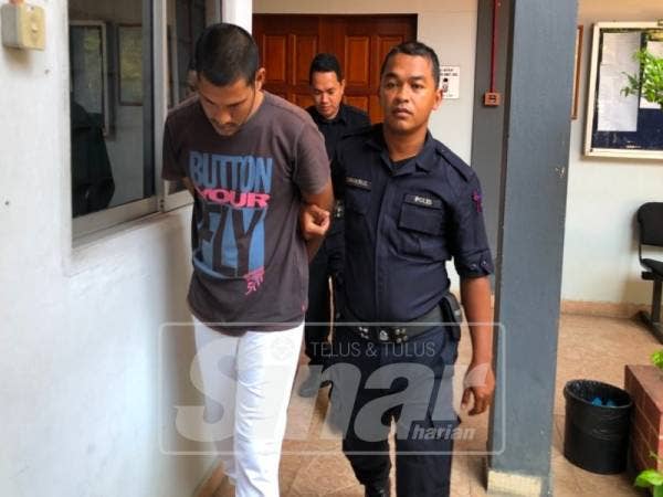 Tertuduh (kiri) dikawal ketat polis keluar dari mahkamah selepas dihukum.