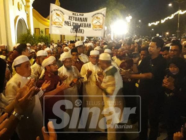 Hadirin membaca doa selepas menyerahkan memorandum di hadapan pintu masuk Istana Anak Bukit.
