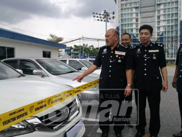 Mohd Kamarudin meninjau kenderaan yang disita dalam serbuan awal pagi tadi.