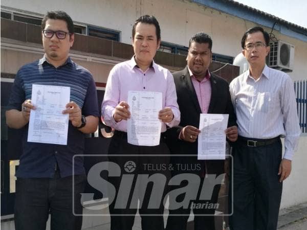 Zhemin (dua, kiri), setelah membuat laporan polis di IPD Ipoh.