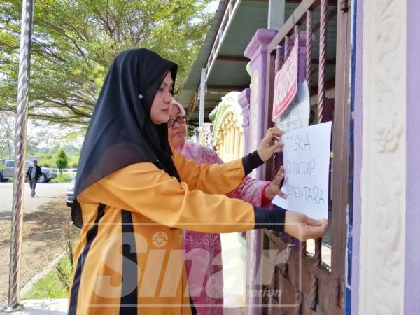 Ruhaini bersama Pegawai Penguat kuasa JKM Perak, Noor Hanizah Zulkfli menunjukkan notis penutupan sementara yang dibuat di sebuah taska.