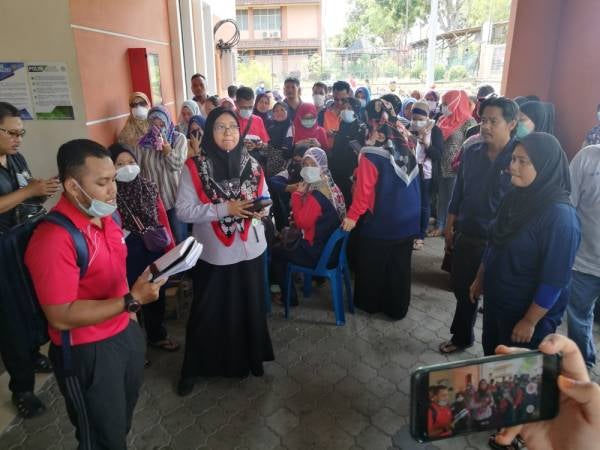 Seorang guru bertugas mengumumkan nama-nama pelajar yang sedang dirawat di dewan.