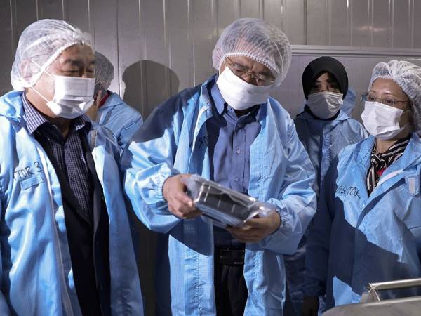 Salahuddin (dua, kiri) melihat durian yang telah siap dibungkus untuk dieksport ke China di Fasiliti Eksport Durian JL Food Industries Sdn Bhd hari ini. - Bernama