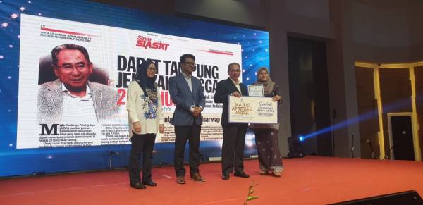 Azihan (kanan) menerima anugerah yang disampaikan oleh Mohd Azizi