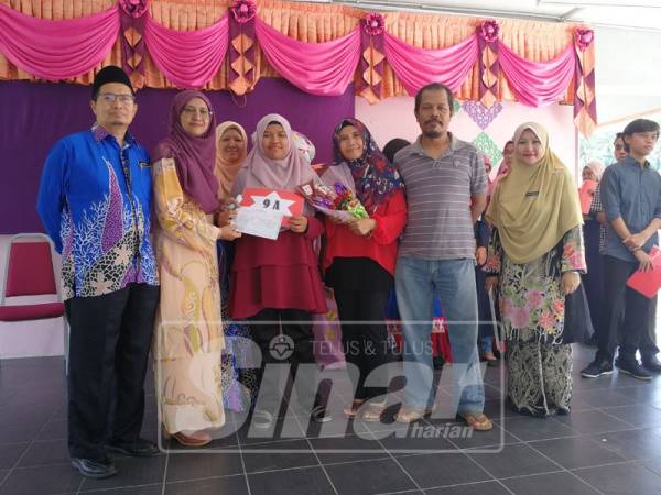 Kalsom (dua, kanan) bersama suaminya merakam kenangan bersama anak bongsunya, Nur Hafizah selepas pengumuman keputusan cemerlang SPM.
