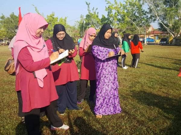 Guru-guru mengadili pertandingan sedang mencatat markah.