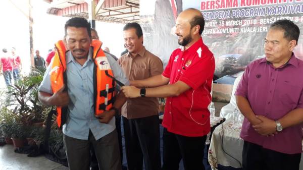 Mukhriz menyampaikan bantuan 'touch point' kepada nelayan setempat.