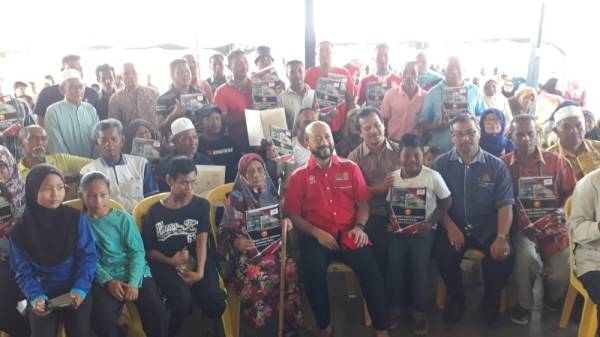 Mukhriz (duduk, tengah) bersama penerima LPS di Jeti Kuala Jerlun, dekat sini.