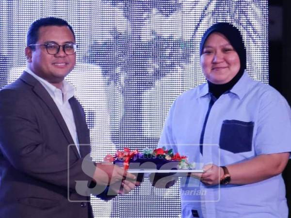 Nur Farhana(kanan) menerima anugerah media yang disampaikan oleh Menteri Besar Selangor Amirudin Shari.