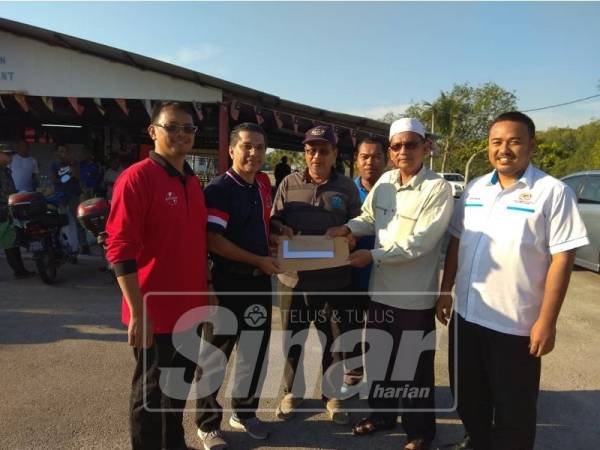 Syed Ibrahim (dua, kiri) menerima kertas kerja daripada Ketua Kampung Kesang, Musa Daud sambil diperhatikan Adun Serom, Dr Ir Faizul Amri Adnan (kanan) dan Penghulu Mukim Serom, Mahathir Abdul Ghani (tiga, kanan).
