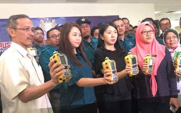 Bee Yin (dua, kanan) menunjukkan alat pengesan gas yang digunakan untuk memantau udara. Foto: Twitter Yeo Bee Yin.