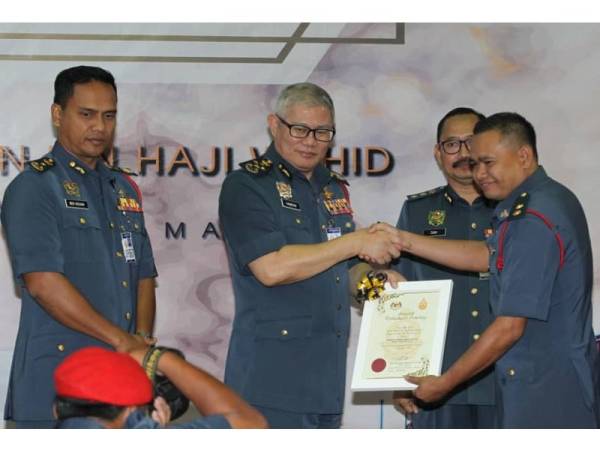 Dari kiri, Nor Hisham dan Mohammad Hamdan ketika menyampaikan anugerah kecemerlangan kepada Komander Operasi Kanan Zon 2, Mohd Arshad Abdullah.