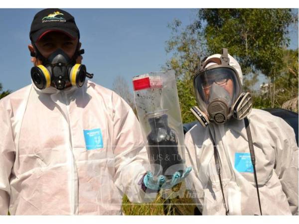 Petugas Jabatan Alam Sekitar menunjukkan sampel yang disambil daripada tong yang dijumpai dibawah jambatan berhampiran SMK Tanjung Puteri Resot, Pasir Gudang hari ini. - Foto Raja Jaafar Ali