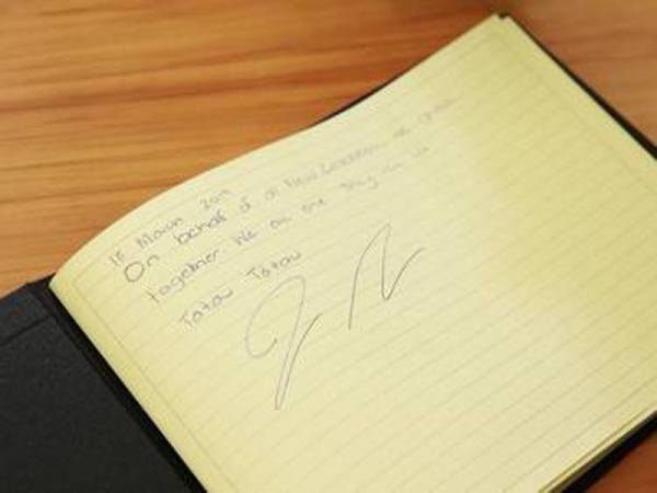 Ardern menandatangani buku takziah buat mangsa serangan pengganas di masjid Christchurch.
