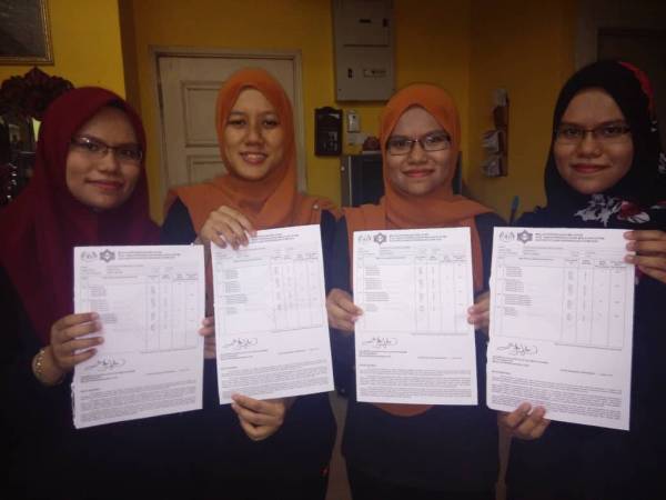 Dari kiri, Intan Norliana, Intan Nordiana, Intan Norfazrina dan Intan Norsyazrina menunjukkan keputusan STPM 2018 mereka.