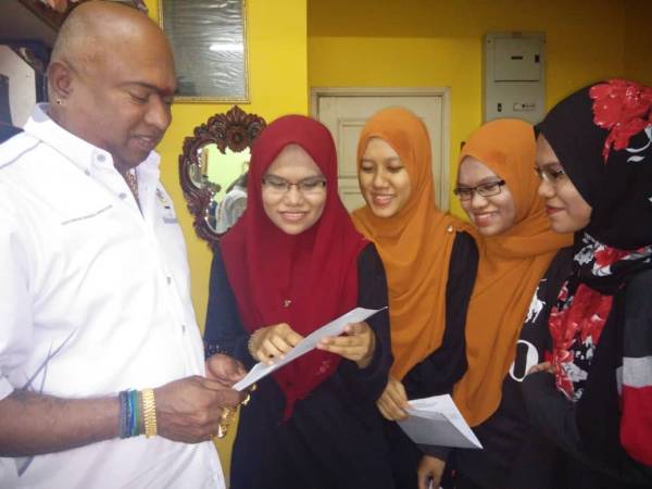 Tangakaliswaran (kiri) melihat keputusan STPM Intan Norliana (dua, kiri) sambil diperhatikan oleh Intan Nordiana, Intan Norfazrina dan Intan Norsyazrina.