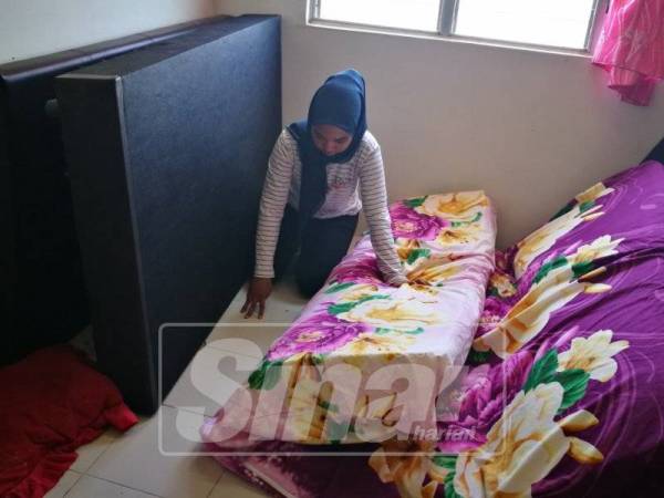 Nor Alia Aqilla menunjukkan lokasi ular bersembunyi ketika ditangkap pihak bomba.