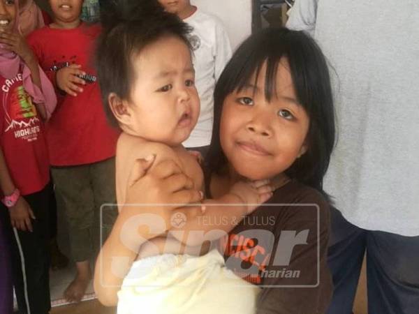 Intan Nabila bersama adiknya yang diselamatkan dalam kebakaran pagi tadi.