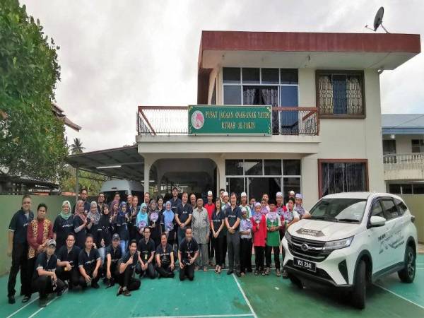 Ahli konvoi bergambar kenangan bersama anak-anak yatim di hadapan bangunan Al Yakin.