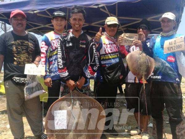 Aznil (hadapan) memegang ikan pari seberat 20.9kg yang membawa kepada kemenangannya.