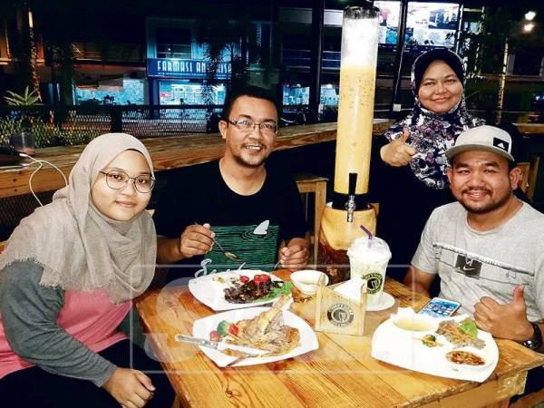 Zawari (kanan) bersama isterinya bergambar bersama pelanggannya.
