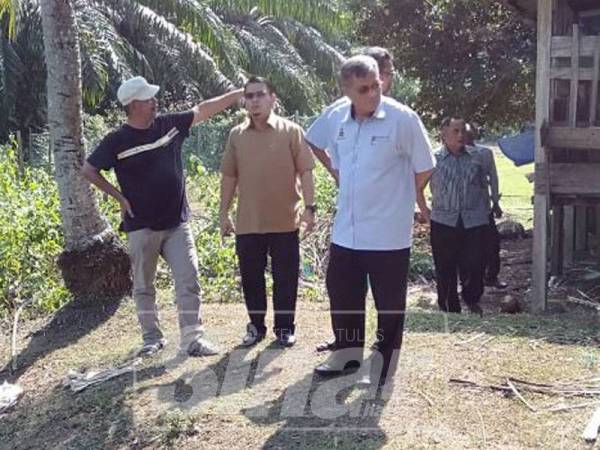 Hussain (tengah) bersama pegawai khas ADUN Ijok meninjau keadaan hasil ternakan kambing penduduk yang diserang anjing liar.