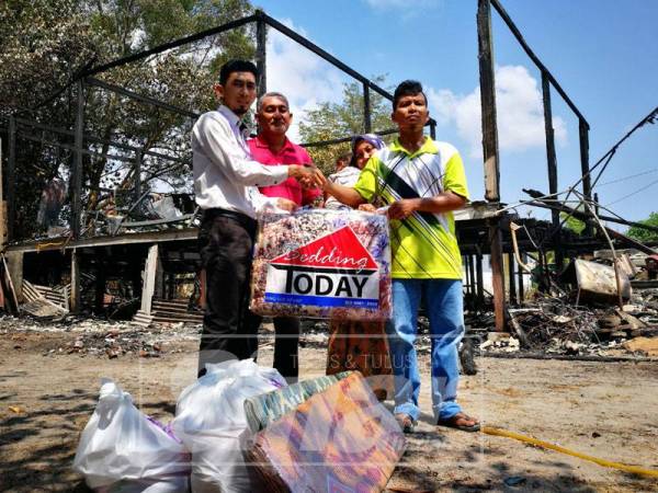 Anuar (kanan) menerima sumbangan disampaikan Pegawai JKM, Mat Nuzaihan dan
Bendahari MPKK Duyung, Che Abdul Azeb.