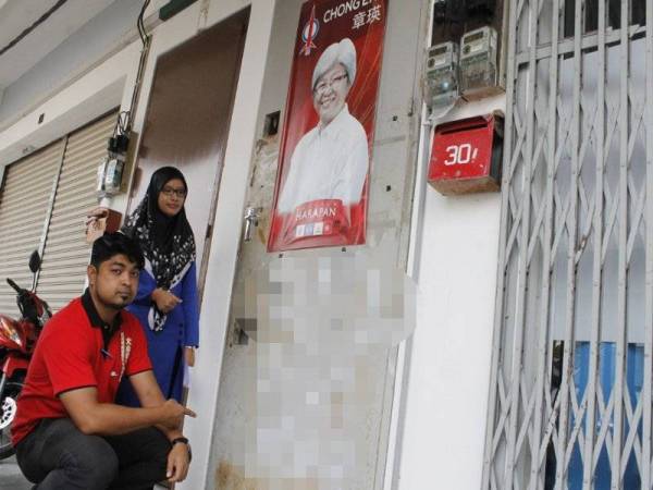 Jothi menunjukkan contengan pada pintu pusat khidmat ADUN Padang Lalang.