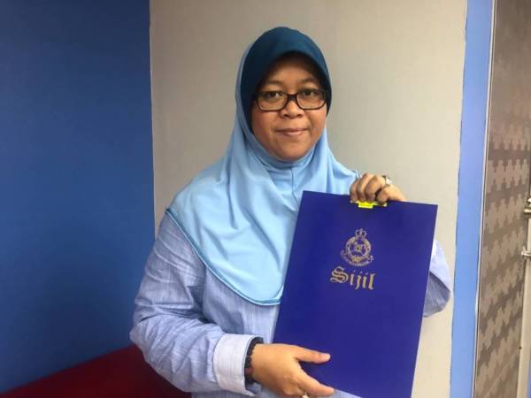 Zaimatuljuwita bersama sijil yang diterima daripada polis.