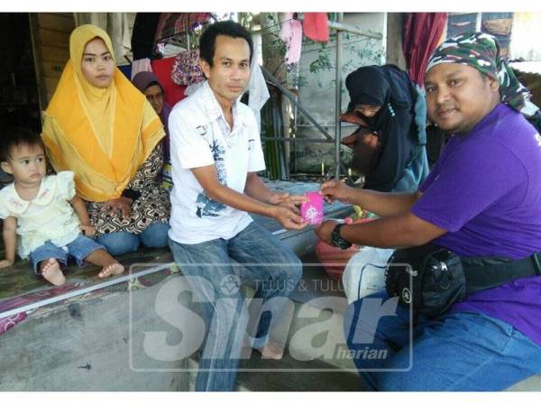 Md Yusazmi (kanan) dalam satu program kebajikan yang disertainya.