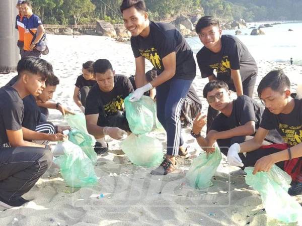 Sambil berjalan sambil kutip sampah di Teluk Chempedak.