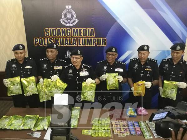 Mazlan (tiga, kiri) menunjukkan rampasan dadah susulan tertangkapnya pasangan kekasih warga tempatan.